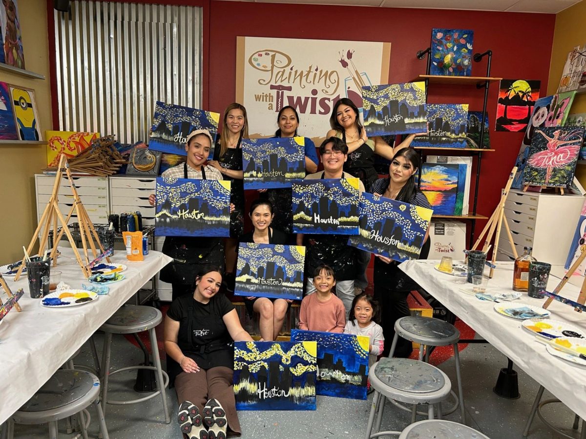 The V Family Dentistry team holding their paintings at a painting night