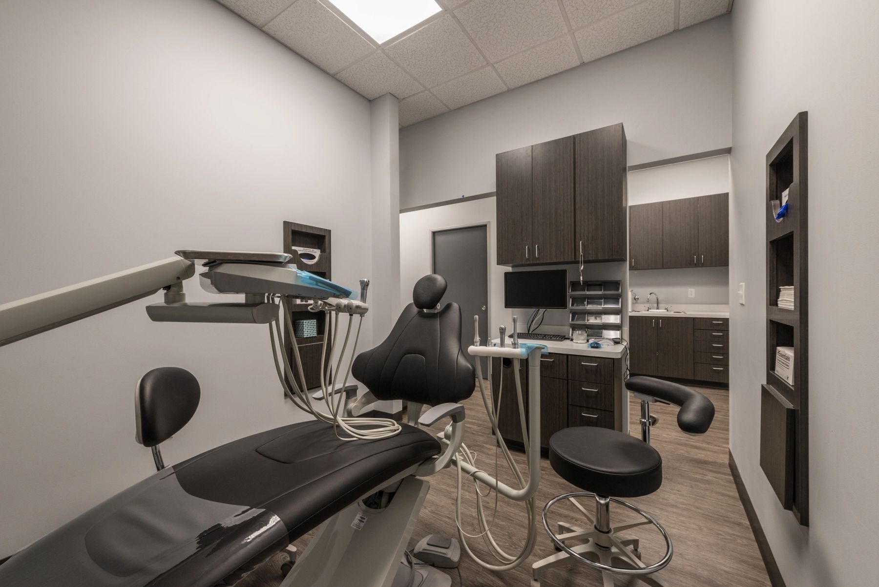 Modern dental treatment room with a wall-mounted screen